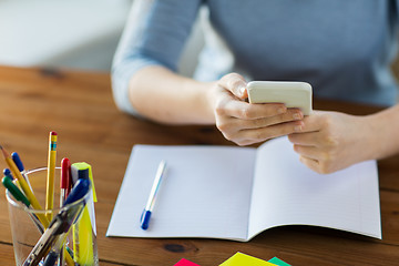 Image showing close up of student with smartphone and notebook