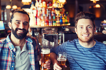 Image showing happy male friends drinking beer at bar or pub