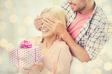 Image showing happy man giving woman gift box at home