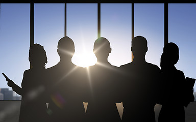 Image showing business people silhouettes over office background