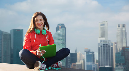 Image showing happy young woman with tablet pc and headphones