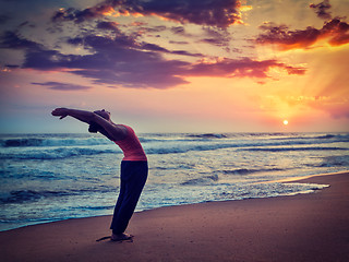 Image showing Young sporty fit woman doing yoga Sun salutation Surya Namaskar