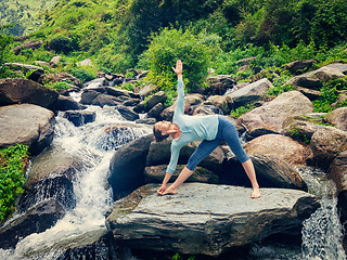 Image showing Woman doing Ashtanga Vinyasa yoga asana Utthita trikonasana