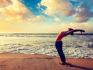 Image showing Young sporty fit woman doing yoga Sun salutation Surya Namaskar 