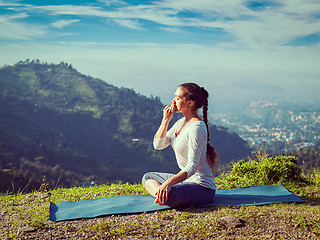 Image showing Woman practices pranayama in lotus pose outdoors