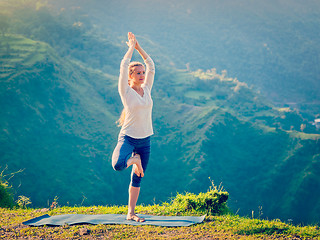 Image showing Woman in  yoga asana Vrikshasana tree pose in mountains outdoors