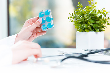 Image showing Hand of female medicine doctor holding tablet blister closeup. 