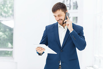 Image showing Portrait of businessman talking on phone in office