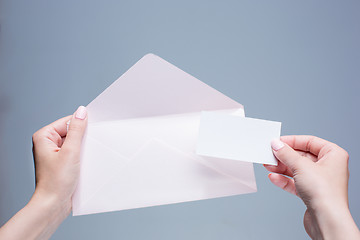 Image showing The female hands with envelope against the gray background