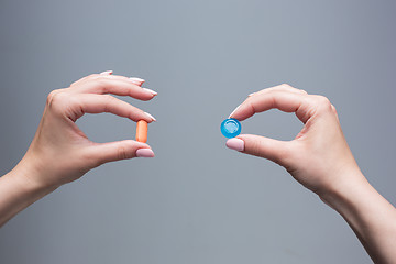 Image showing The female hands with sweet candy and pills 