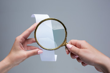 Image showing The female hands with  empty transaction paper or paper check and magnifier