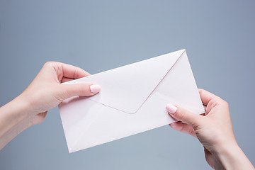 Image showing The female hands with envelope against the gray background