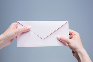 Image showing The female hands with envelope against the gray background