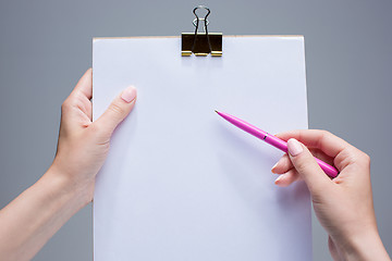 Image showing The notepad and pen in female hands