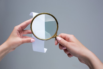 Image showing The female hands with  empty transaction paper or paper check and magnifier