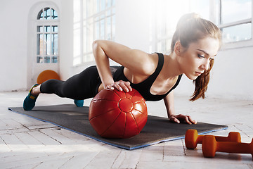 Image showing Beautiful slim brunette doing some gymnastics at the gym