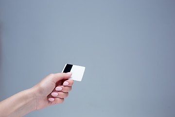 Image showing The card in a female hand is on a gray background