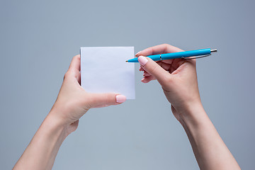 Image showing The notepad and pen in female hands