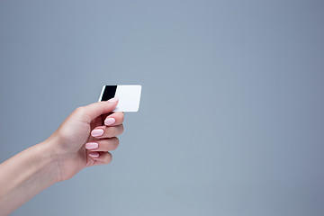 Image showing The card in a female hand is on a gray background