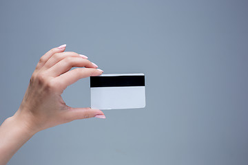 Image showing The card in a female hand is on a gray background