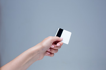 Image showing The card in a female hand is on a gray background