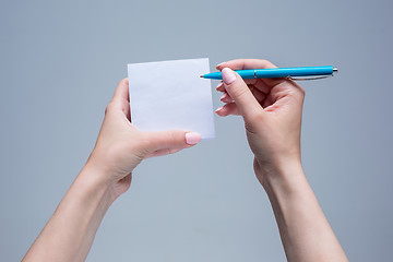 Image showing The notepad and pen in female hands