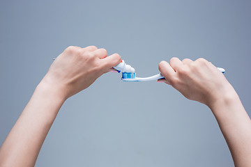 Image showing Toothbrush in woman\'s hands on gray