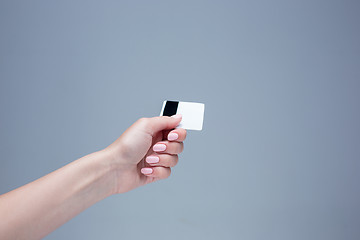 Image showing The card in a female hand is on a gray background