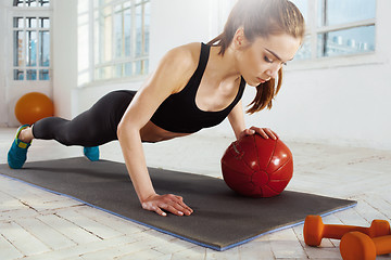 Image showing Beautiful slim brunette doing some gymnastics at the gym