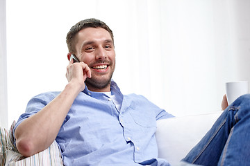 Image showing smiling man with smartphone at home