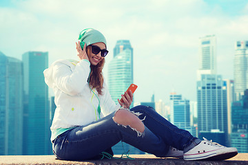 Image showing happy young woman with smartphone and headphones