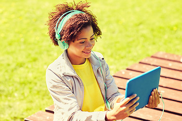 Image showing happy african woman in headphones with tablet pc