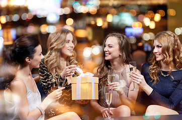 Image showing happy women with champagne and gift at night club