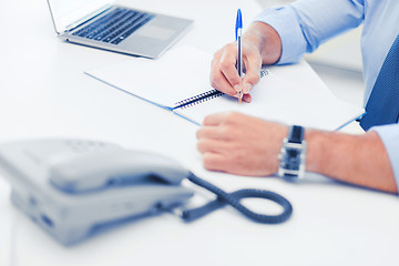 Image showing businessman writing in notebook