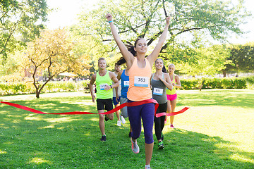 Image showing happy young female runner winning on race finish