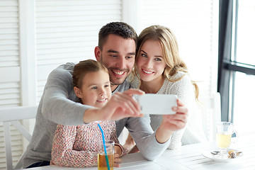 Image showing happy family taking selfie at restaurant