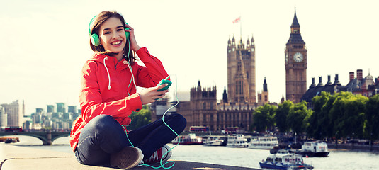 Image showing happy young woman with smartphone and headphones