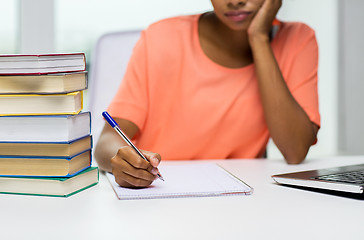 Image showing close up of woman with laptop and books at home