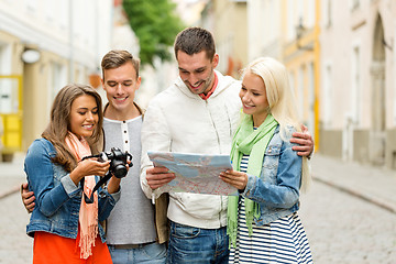 Image showing group of smiling friends with map and photocamera