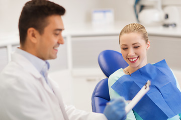 Image showing happy male dentist with woman patient at clinic