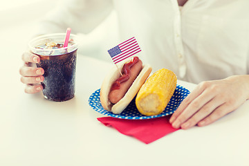 Image showing close up of woman eating hot dog with cola