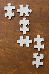 Image showing close up of puzzle pieces on wooden surface