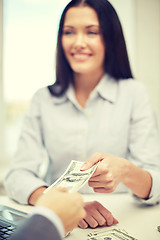 Image showing close up of happy woman giving or exchanging money