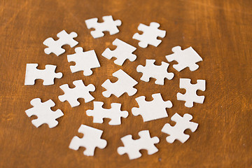 Image showing close up of puzzle pieces on wooden surface