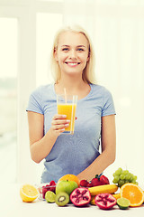 Image showing smiling woman drinking fruit juice at home