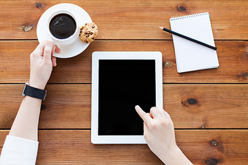 Image showing close up of woman with tablet pc on wooden table