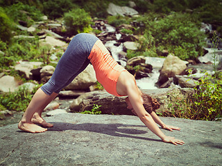 Image showing Young sporty fit woman doing yoga oudoors at tropical waterfall