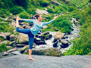 Image showing Woman doing yoga asana Natarajasana outdoors at waterfall