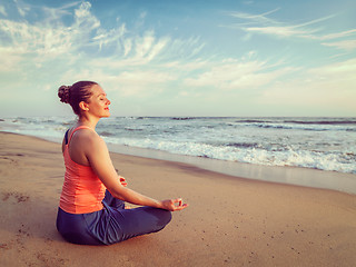 Image showing Young sporty fit woman doing yoga oudoors at beach