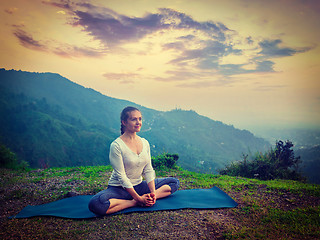 Image showing Sporty fit woman practices yoga asana Baddha Konasana outdoors